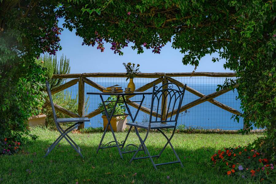 Breakfast for two, beneath the wisteria, with the sea beyond.
