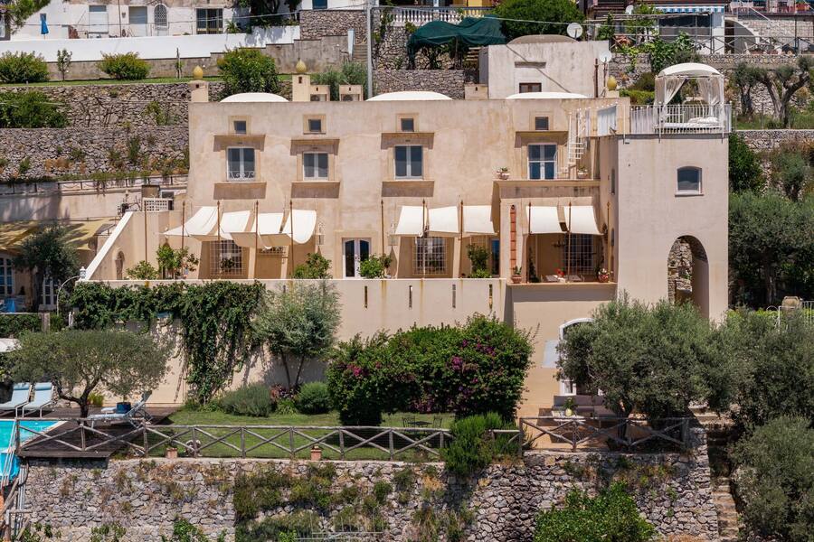 The fortified house, still standing today, and an Escher depiction of a house on the Amalfi Coast.
